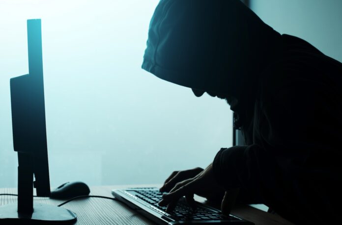 Hooded computer hacker hacking network
