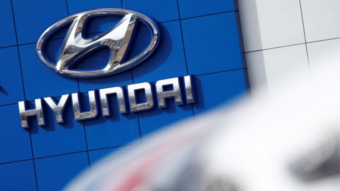 FILE- In this April 15, 2018, file photo, the company logo hangs on the side of a showroom at a Hyundai dealer in Littleton, Colo. The National Highway Traffic Safety Administration's Office of Defects Investigation has opened a query into seat belt pretensioners on certain 2020-2022 Kia/Hyundai vehicles, saying that they may rupture or explode. A seat belt pretensioner is a part of the seat belt system that locks the seat belt in place during a crash.  (AP Photo/David Zalubowski, File)