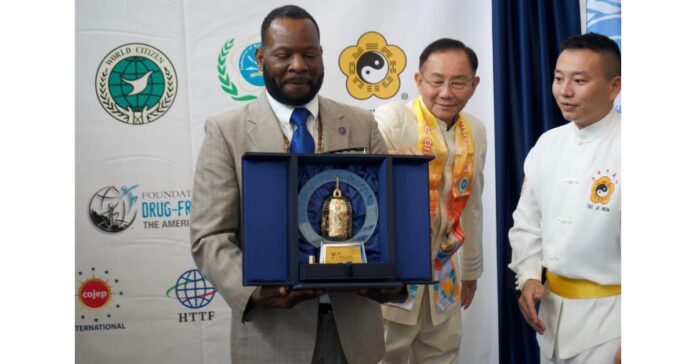 Ambassador Dr. Hugues Sanon receives the Fowpal and Dr. Hong's mini Golden Bell for his promotion of peace and love
