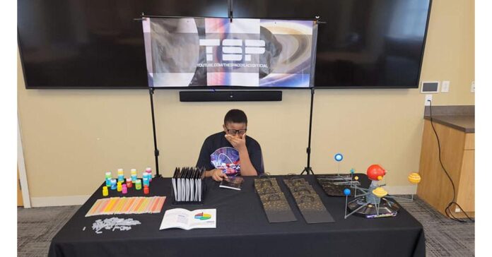 Dr. Frederic Bertley, COSI President and CEO, is inspiring young Joshua Carter into the science industry