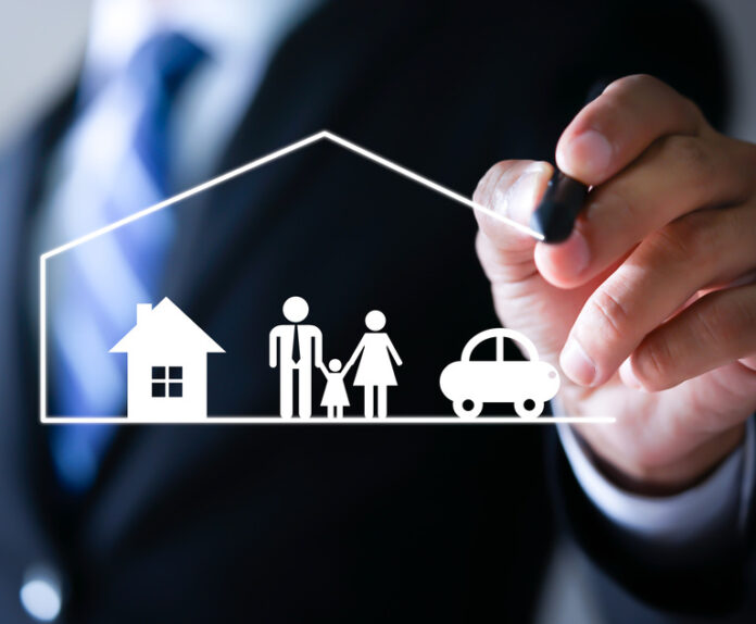 Businessman drawing protective and car, family, life and health insurance icons. Insurance concept. Credit: Worawut/Adobe Stock